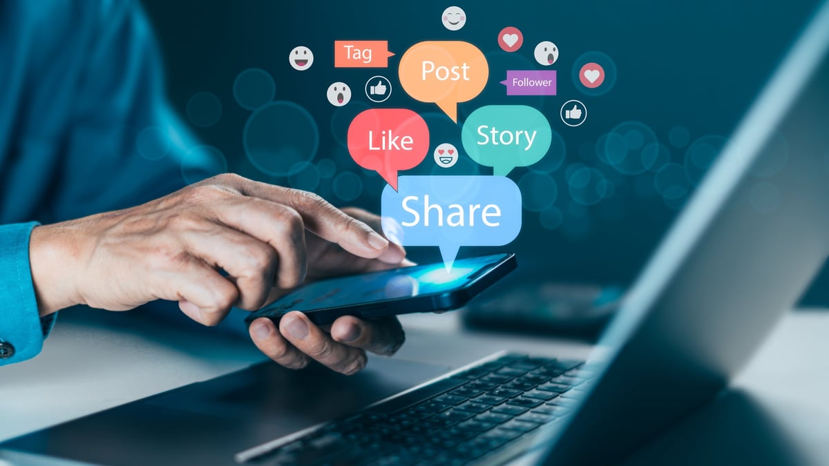 Ruka koja komunicira sa smartphoneom koji prikazuje Like, Share i Post ikone - Social media marketing, digital communication i online content promotion za brand building i audience connection